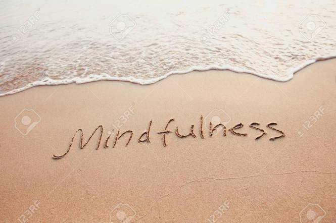 mindfulness concept, mindful living, text written on the sand of beach
